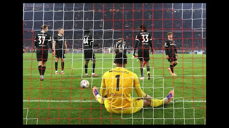 Cầu thủ Freiburg với trang phục đỏ đang tranh chấp bóng với cầu thủ Mainz trong trận đấu.